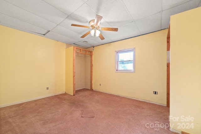 unfurnished bedroom featuring carpet flooring, a paneled ceiling, and ceiling fan