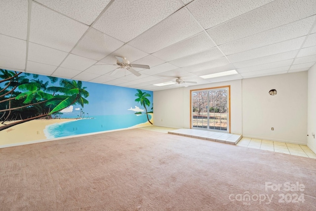 carpeted spare room with a paneled ceiling and ceiling fan