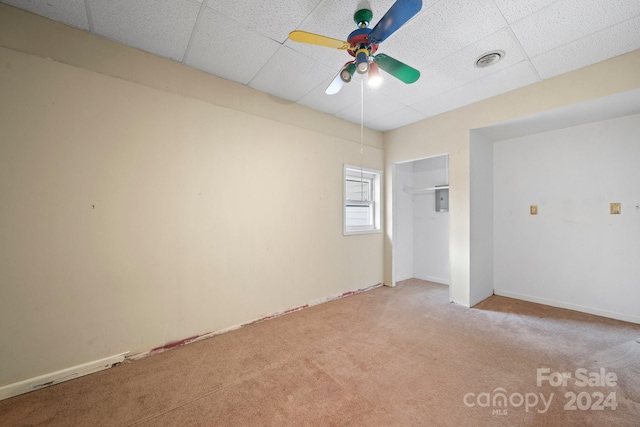 spare room with a paneled ceiling, light colored carpet, and ceiling fan