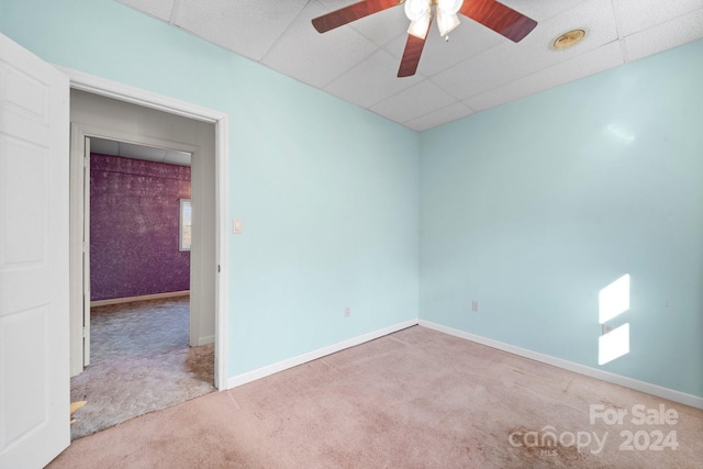 carpeted empty room featuring a paneled ceiling and ceiling fan