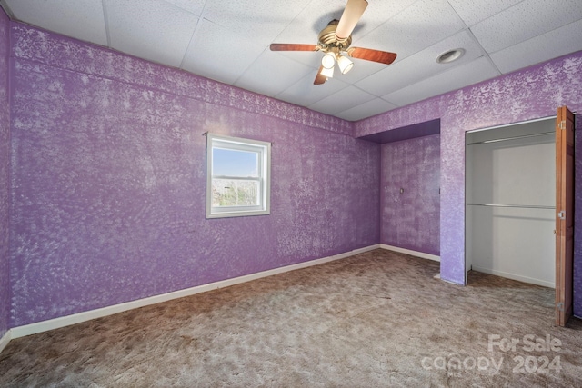 unfurnished bedroom featuring carpet flooring, a paneled ceiling, and ceiling fan