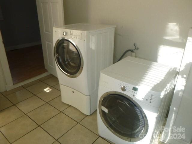 washroom with separate washer and dryer and light tile patterned floors