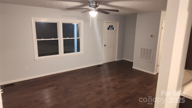 unfurnished room with ceiling fan, dark hardwood / wood-style flooring, and a textured ceiling