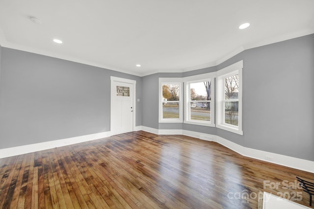 unfurnished room featuring hardwood / wood-style floors and ornamental molding