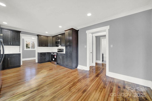 kitchen featuring crown molding, light hardwood / wood-style flooring, dark brown cabinets, stainless steel appliances, and tasteful backsplash