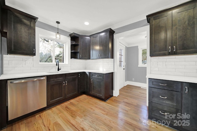 kitchen with pendant lighting, sink, light hardwood / wood-style flooring, dark brown cabinets, and stainless steel dishwasher