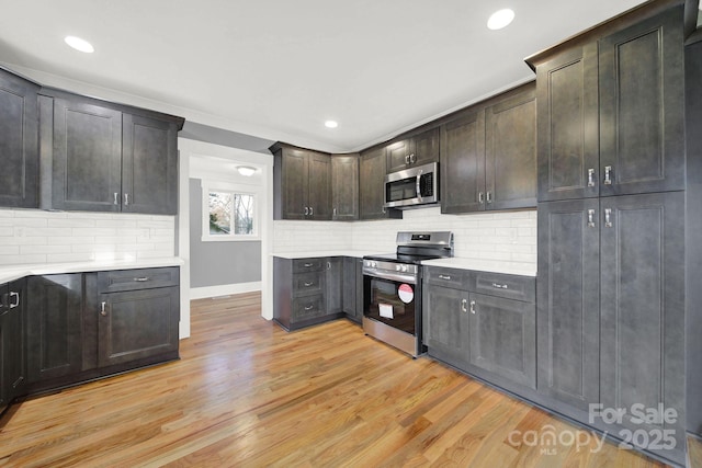 kitchen with decorative backsplash, stainless steel appliances, dark brown cabinets, and light wood-type flooring