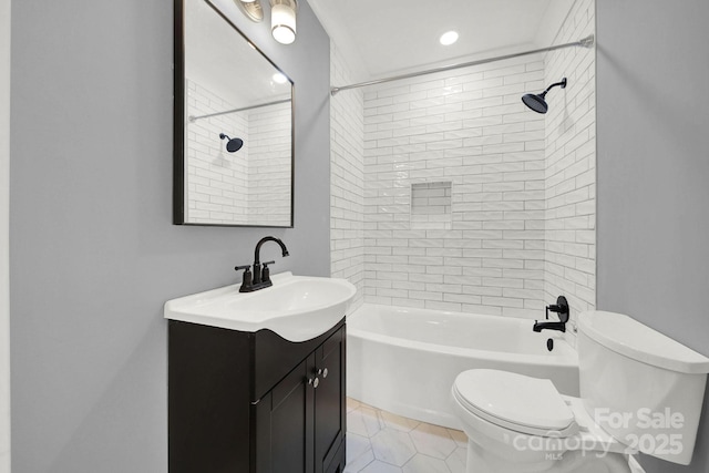 full bathroom featuring vanity, toilet, tiled shower / bath combo, and tile patterned flooring