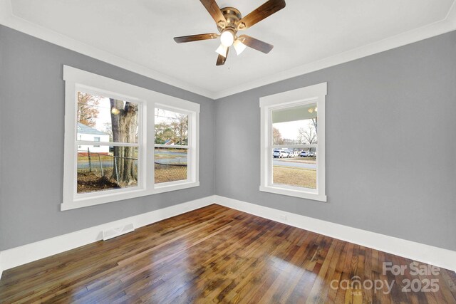 empty room featuring ceiling fan, ornamental molding, and dark hardwood / wood-style flooring