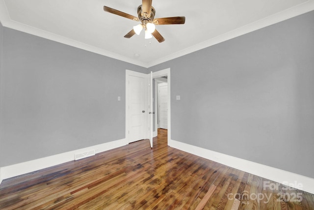 empty room featuring crown molding, dark wood-type flooring, and ceiling fan