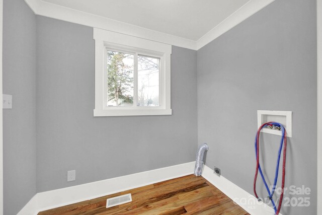 laundry area featuring ornamental molding, wood-type flooring, and hookup for a washing machine