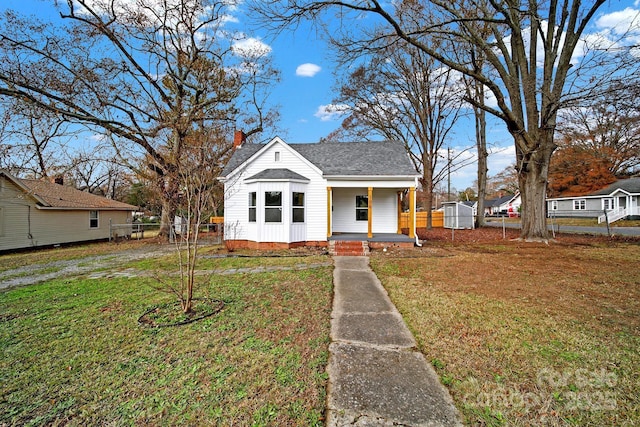 bungalow featuring a porch and a front lawn