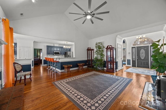 living room featuring high vaulted ceiling, dark hardwood / wood-style floors, and ceiling fan with notable chandelier