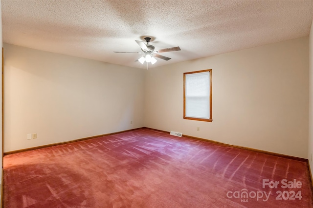 spare room featuring carpet, ceiling fan, and a textured ceiling