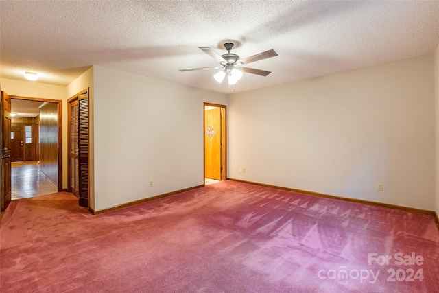 carpeted empty room with ceiling fan and a textured ceiling