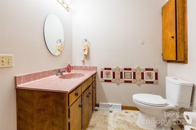 bathroom with tile patterned flooring, vanity, and toilet