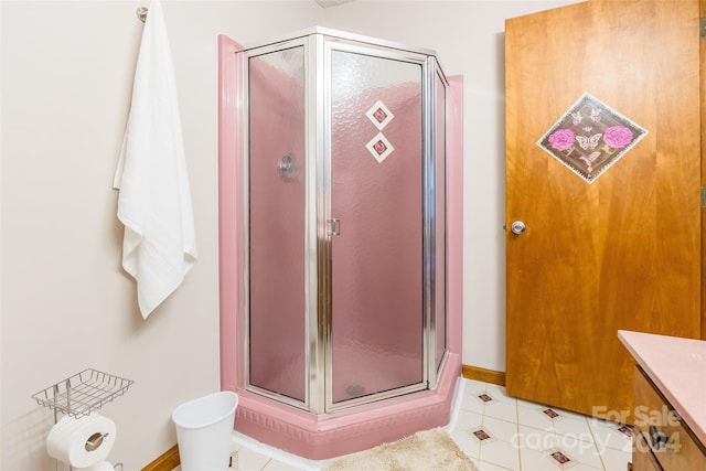 bathroom with tile patterned floors, vanity, and a shower with door