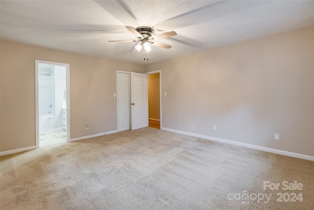 empty room with a textured ceiling, ceiling fan, and light carpet