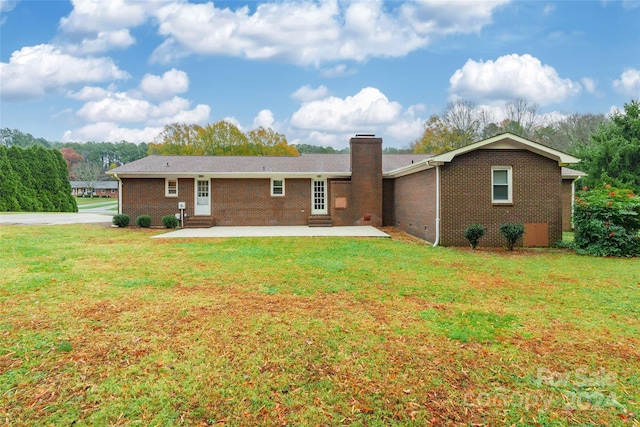 rear view of property featuring a patio area and a yard