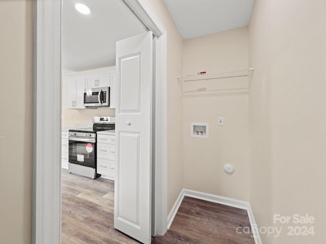 clothes washing area with hookup for a gas dryer, hookup for a washing machine, and light hardwood / wood-style flooring