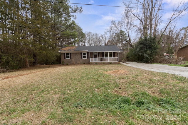 single story home with a porch and a front yard