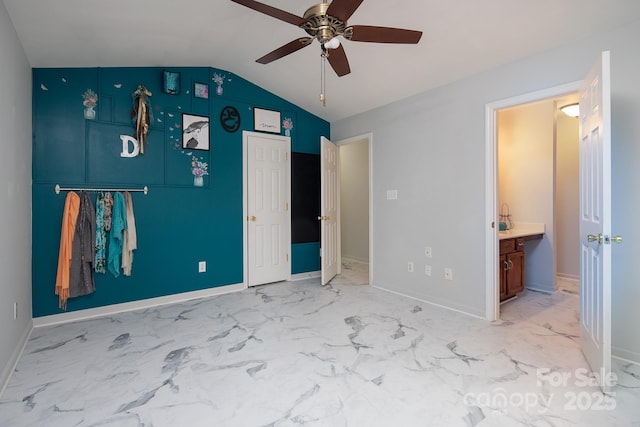 unfurnished bedroom with ceiling fan, ensuite bathroom, and vaulted ceiling