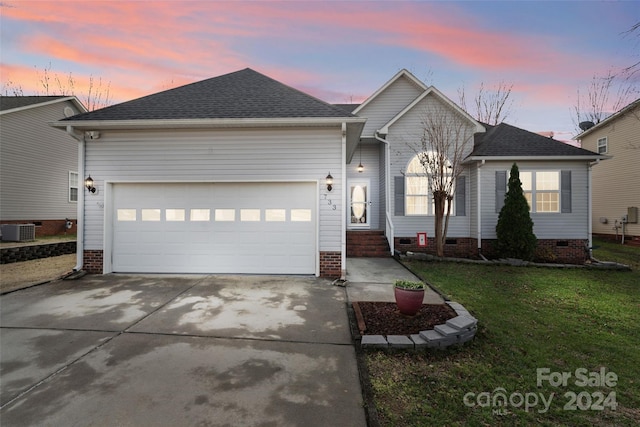 single story home featuring central AC, a yard, and a garage