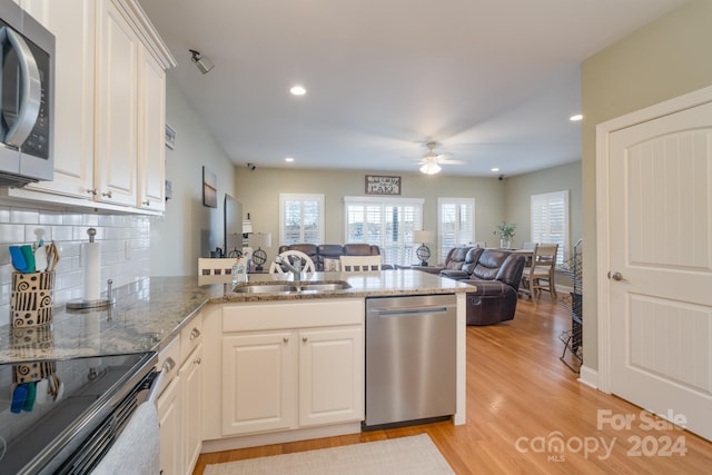 kitchen featuring white cabinetry, ceiling fan, sink, stainless steel appliances, and light hardwood / wood-style floors