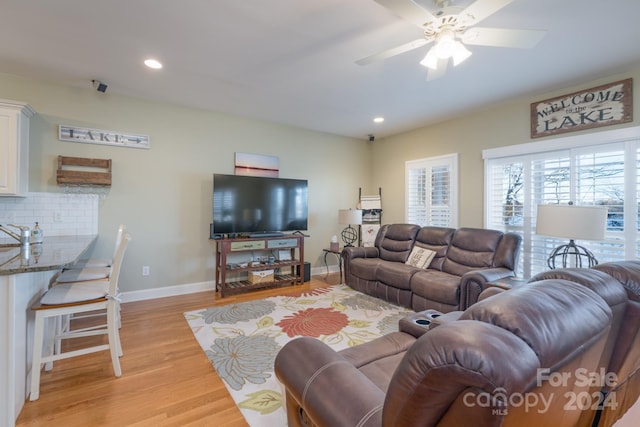 living room featuring light wood-type flooring and ceiling fan