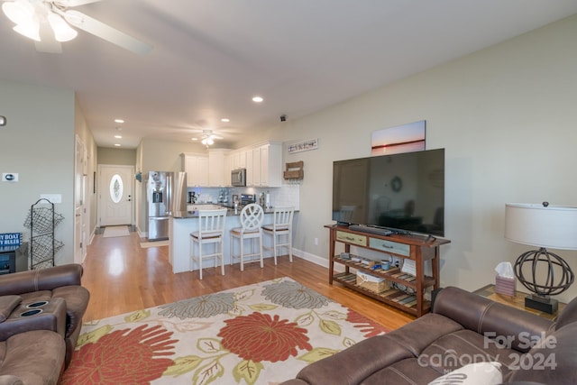 living room featuring light hardwood / wood-style flooring and ceiling fan