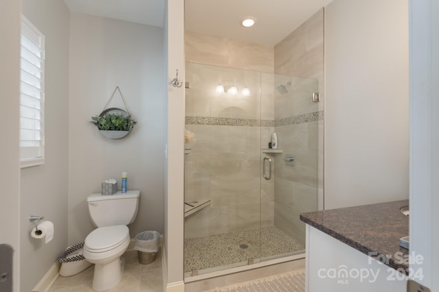 bathroom featuring tile patterned flooring, vanity, an enclosed shower, and toilet