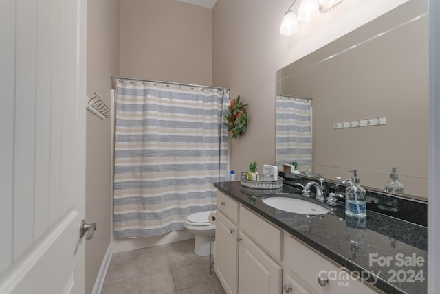 bathroom with tile patterned floors, walk in shower, vanity, and toilet