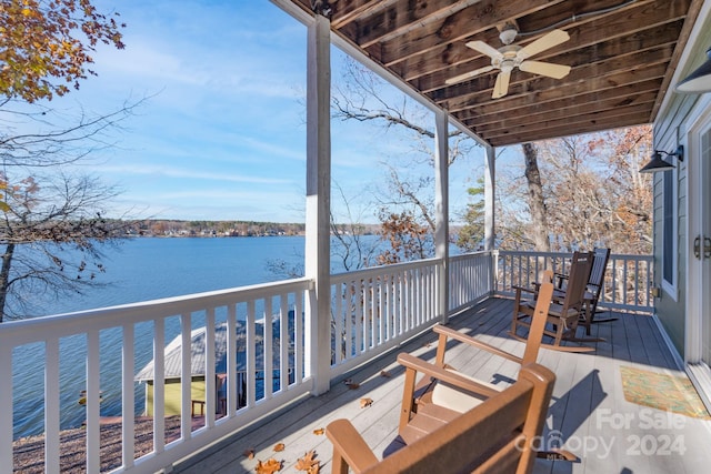 wooden deck with ceiling fan and a water view