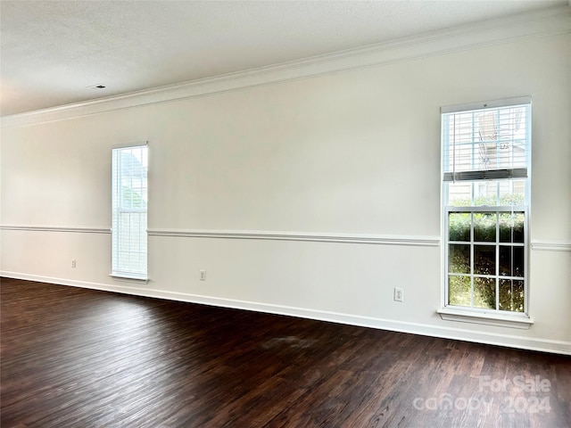 unfurnished room featuring plenty of natural light, dark wood-type flooring, and ornamental molding