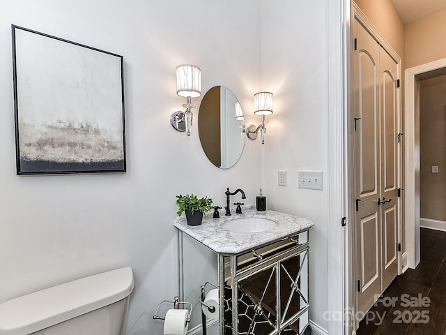 bathroom featuring hardwood / wood-style flooring, vanity, and toilet