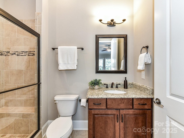 bathroom with vanity, a shower with door, and toilet