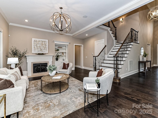 living room featuring built in features, ornamental molding, dark hardwood / wood-style flooring, and a notable chandelier