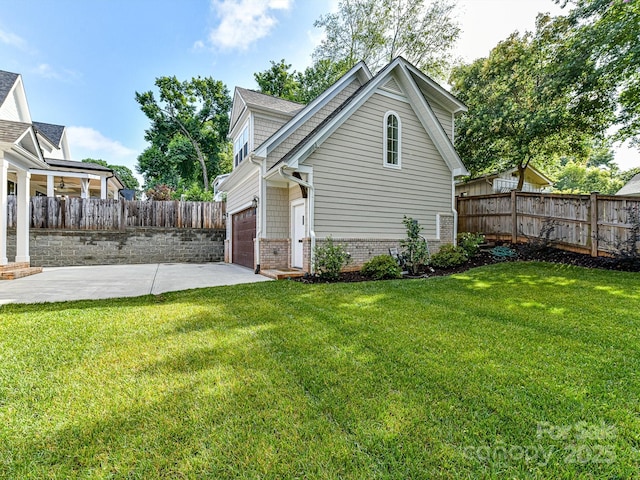 view of side of property with a patio area, a garage, and a yard