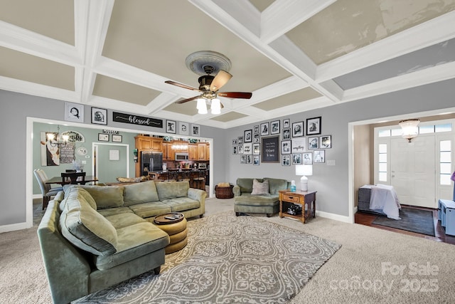 carpeted living room with baseboards, ceiling fan with notable chandelier, and coffered ceiling