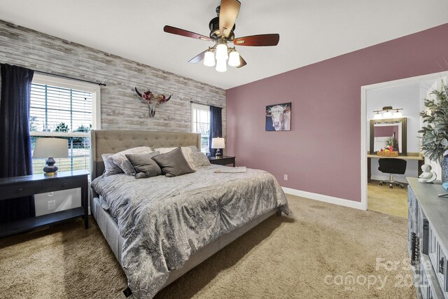 carpeted bedroom featuring baseboards, ceiling fan, and an accent wall