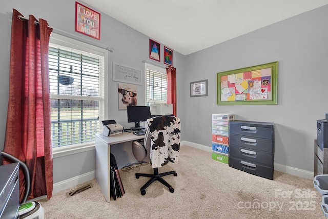 carpeted office space featuring baseboards, visible vents, and plenty of natural light