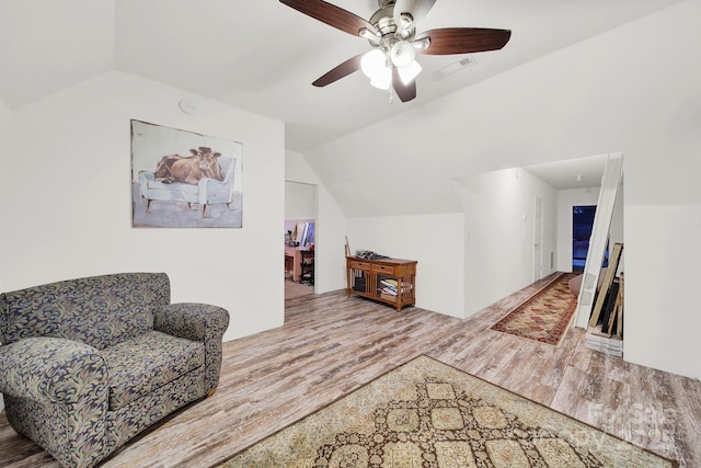 living area with wood finished floors, ceiling fan, lofted ceiling, and visible vents