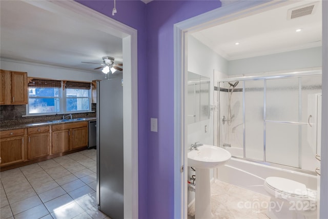 full bathroom featuring shower / bath combination with glass door, backsplash, sink, tile patterned flooring, and ceiling fan