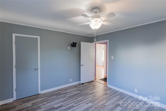 spare room with ceiling fan, wood-type flooring, and ornamental molding