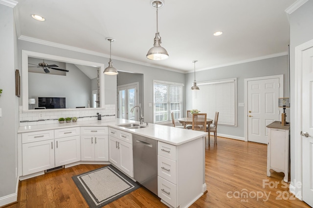 kitchen featuring white cabinetry, sink, hanging light fixtures, stainless steel dishwasher, and kitchen peninsula