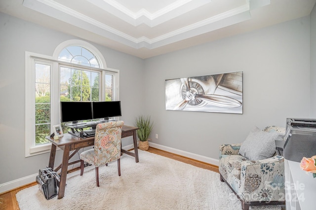 office space with plenty of natural light, light wood-type flooring, ornamental molding, and a tray ceiling