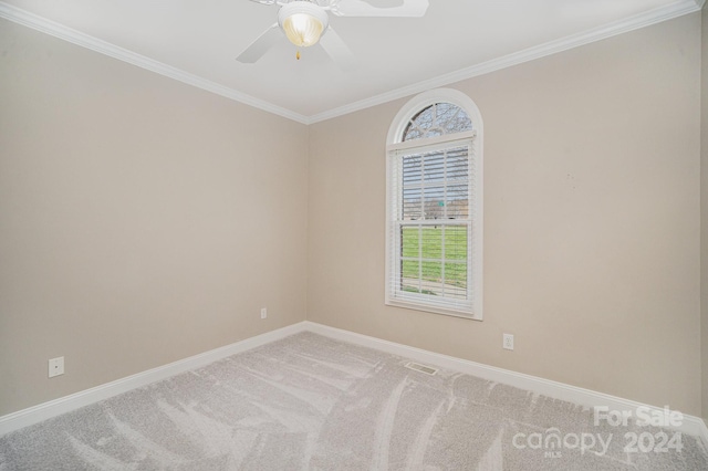 empty room with light carpet, ceiling fan, and crown molding