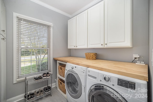 laundry area with cabinets, washing machine and dryer, and ornamental molding