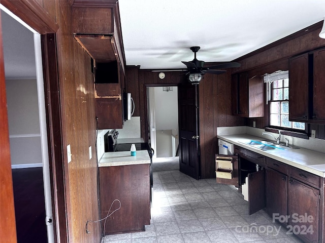 kitchen with appliances with stainless steel finishes, dark brown cabinetry, and wood walls