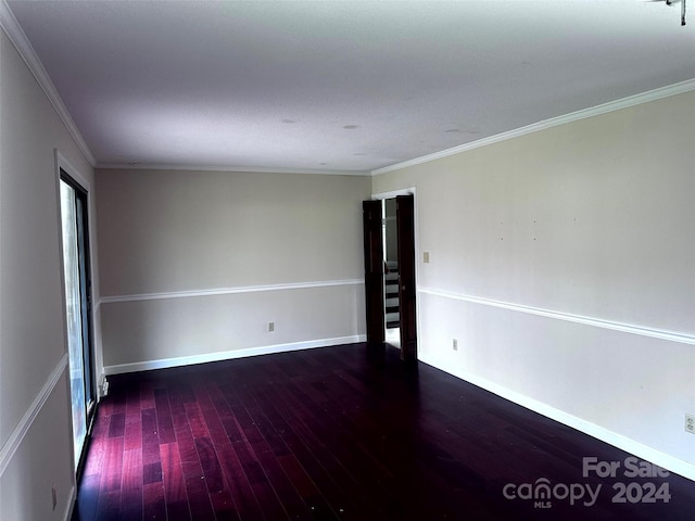 unfurnished room featuring ornamental molding and dark wood-type flooring